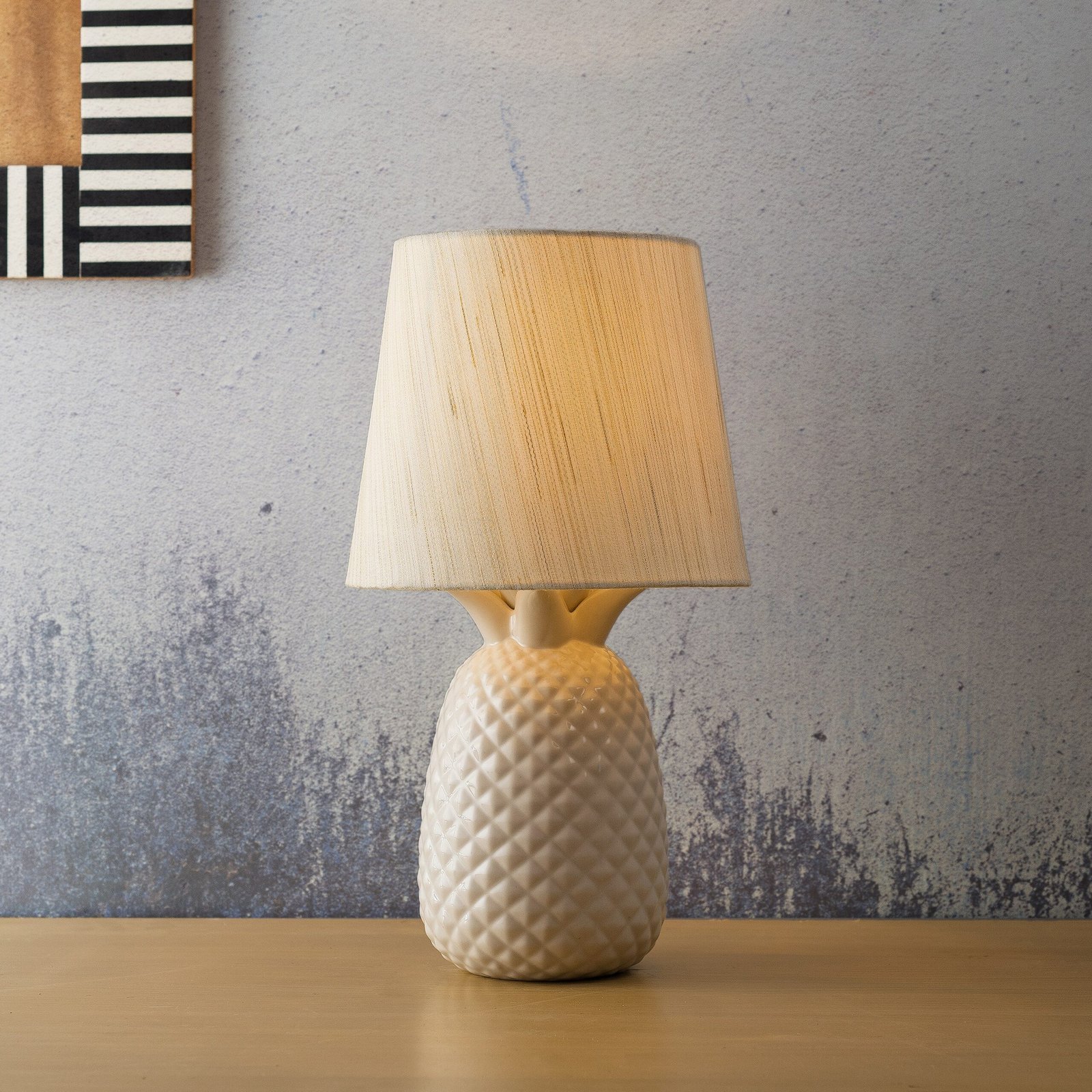 a white table lamp sitting on top of a wooden table